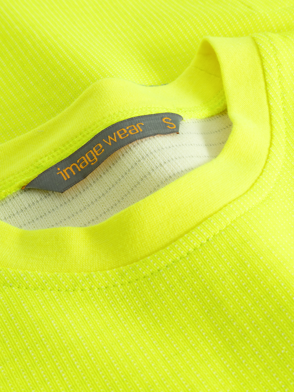 Yksityiskohtakuva keltaisen näkyvän palosuojatun collegepaidan pääntiestä. 