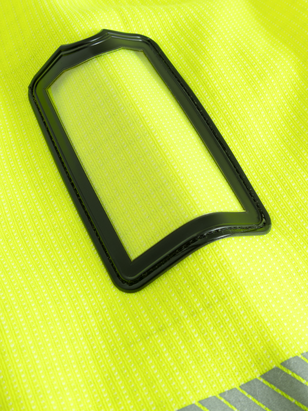 Yksityiskohtakuva keltaisen näkyvän palosuojatun collegepaidan henkilökorttikotelosta. 