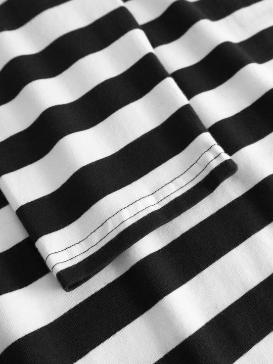 Yksityiskohtakuva mustavalkoraidallisen trikoopaidan hihansuusta. 