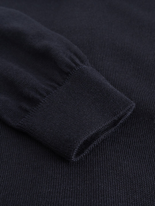 Yksityiskohtakuva tummansinisen neuletakin hihansuun resorista.