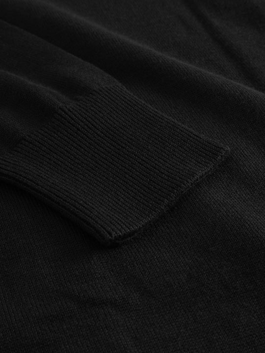 Yksityiskohtakuva mustan Nelli-neuletakin hihansuun resorista. 