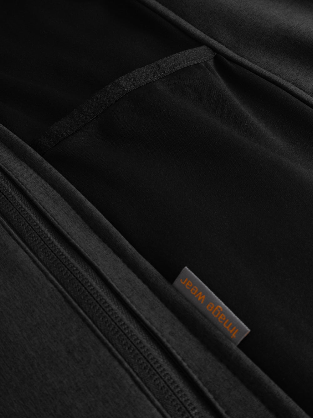 Yksityiskohtakuva softshell-takin sivuosasta. Väritys meleerattu musta. 