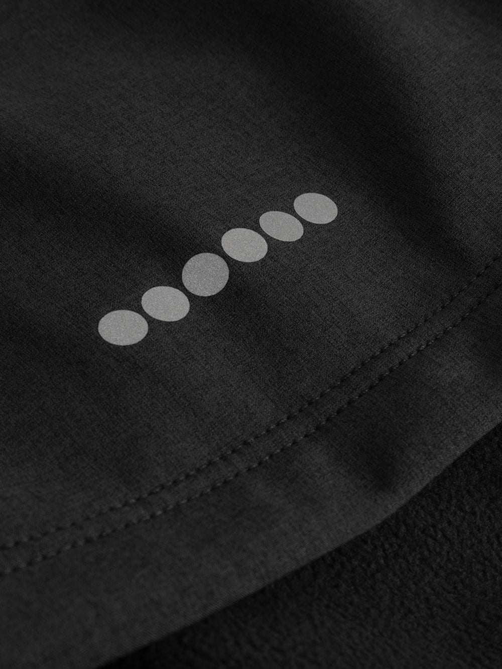 Yksityiskohtakuva softshell-takin heijastimesta. 