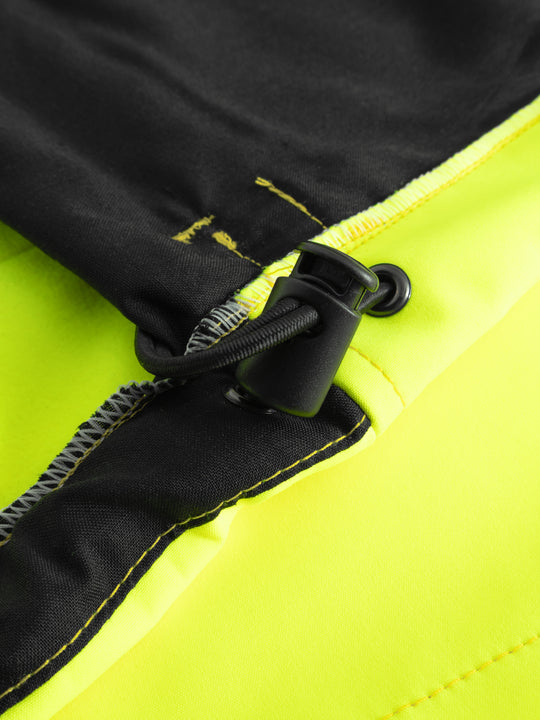 Yksityiskohtakuva keltaisen varoitussoftshell-takin helman kiristysmekanismista takin sisäpuolelta. 