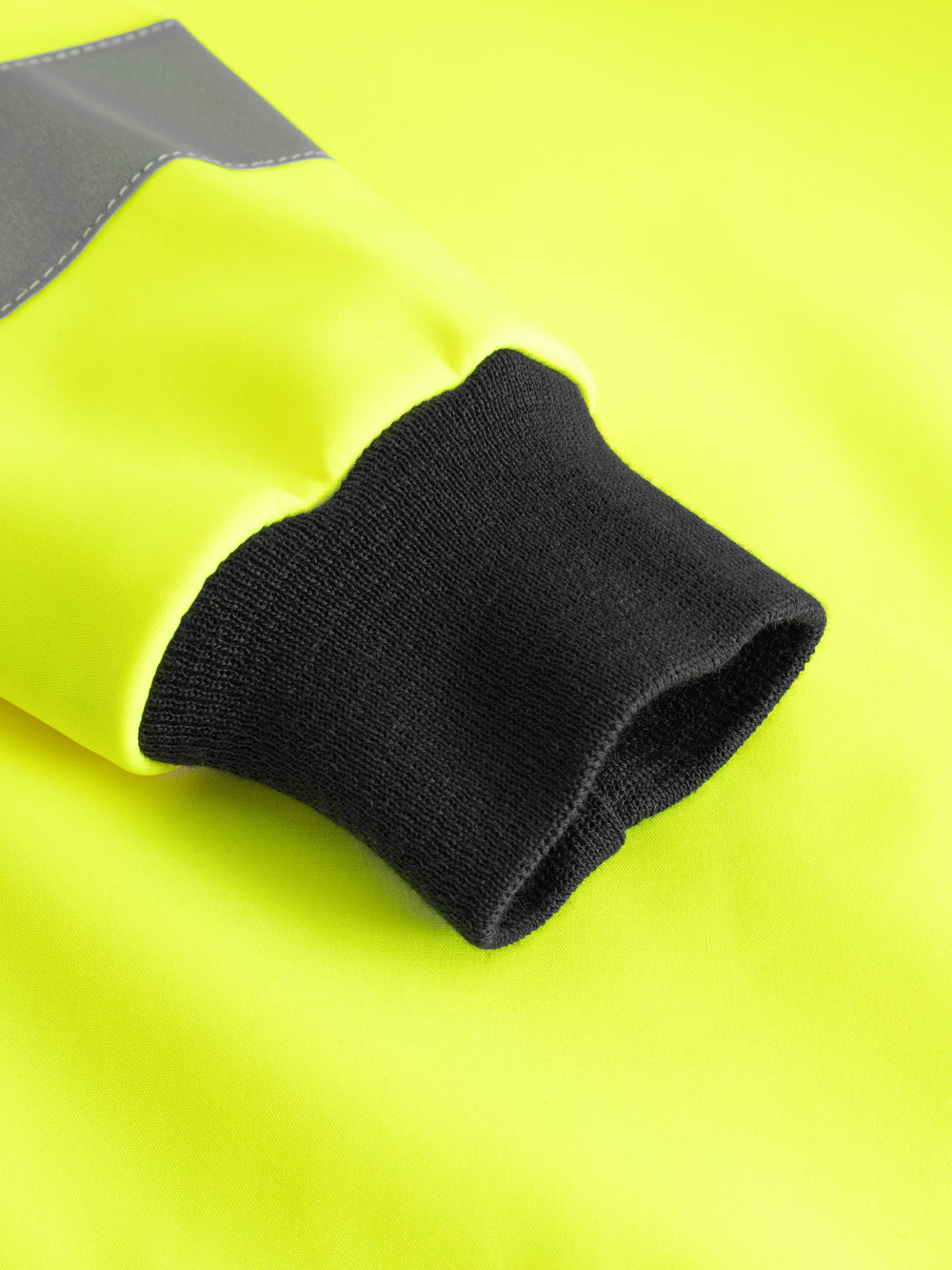 Yksityiskohtakuva keltaisen varoitussoftshell-takin hihansuun resorista. 