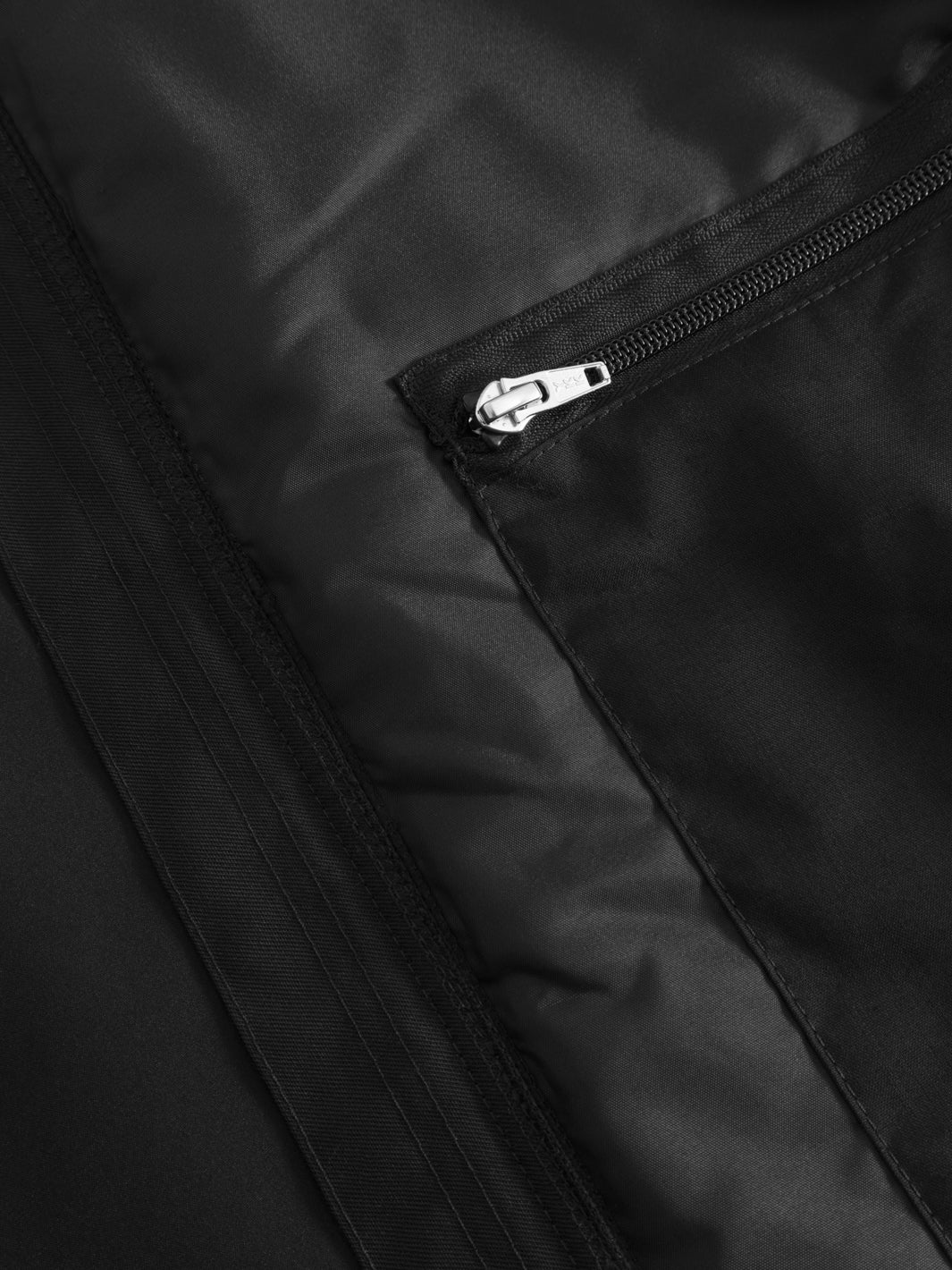 Yksityiskohtakuva mustan välikausitakin vetoketjullisesta povitaskusta. 