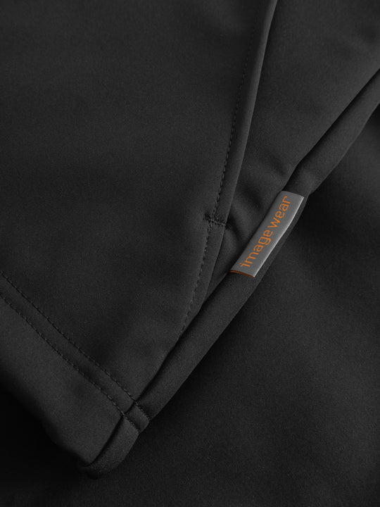 Yksityiskohtakuva mustan välikausitakin sivusaumasta ja Image Wearin merkistä. 