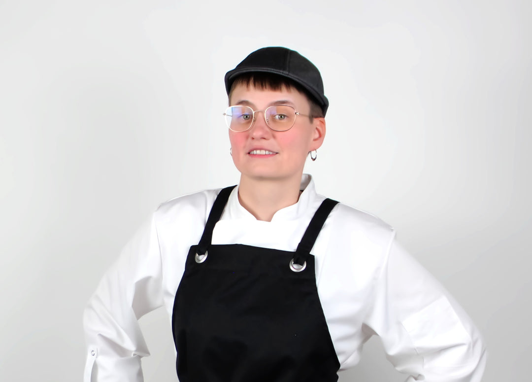 Kuvassa mallilla päällä Image Wearin musta kokkilätsä, valkoinen kokkitakki ja musta Ergofit-essu. 