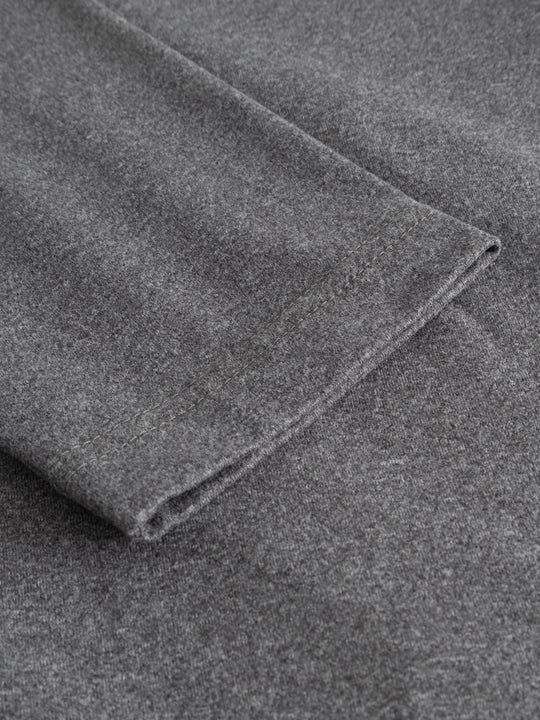 Yksityiskohtakuva harmaan mekon hihansuusta. 