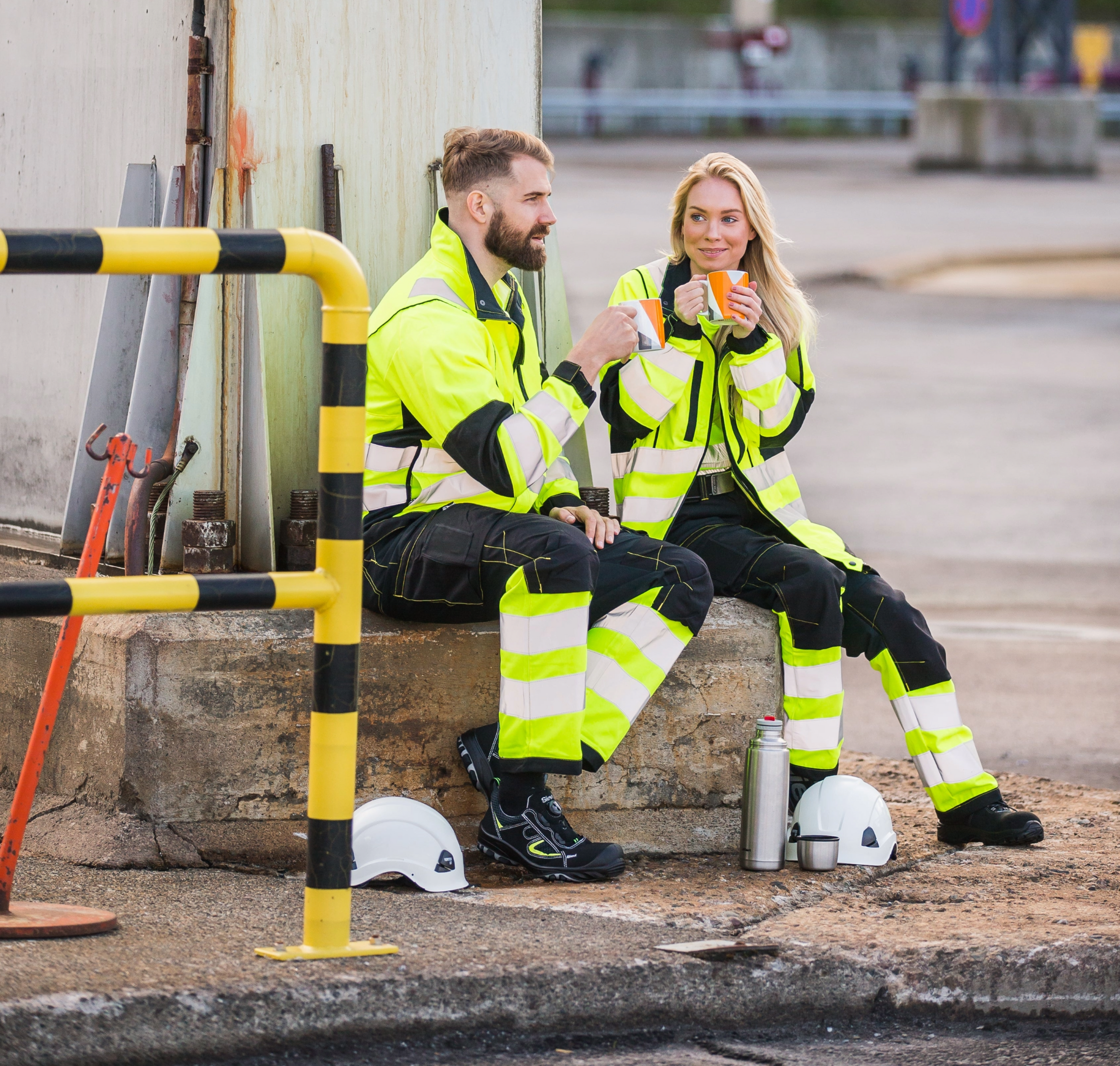 Kuvassa nainen ja mies Image Wearin keltaisissa huomiovärisissä teollisuus- ja rakennusalan työvaatteissa. 